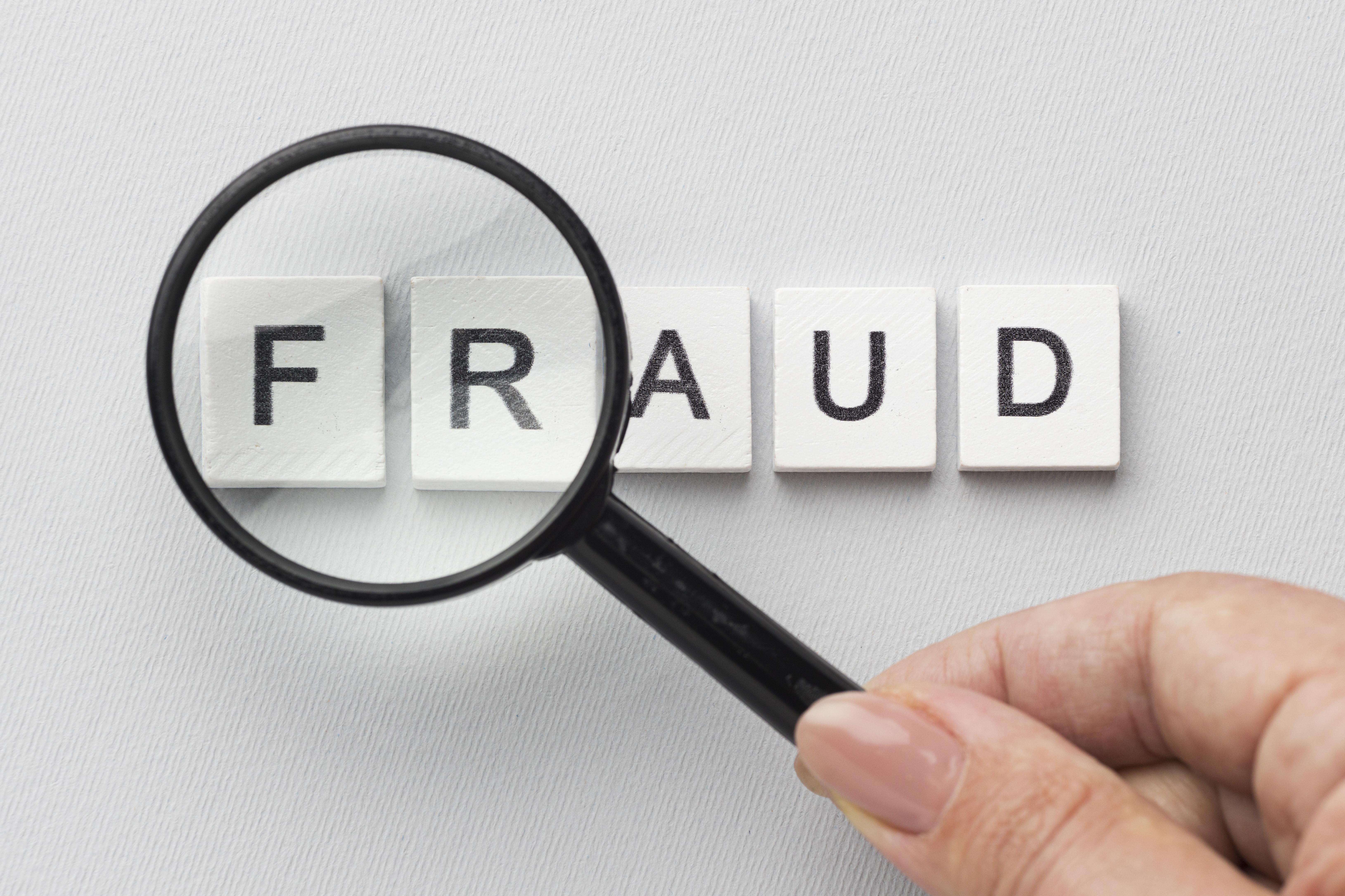 magnifying glass shwing word fraud Criminal history fraud in a magnifying glass